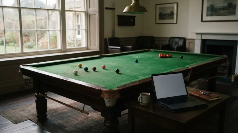 Pusty stół snookerowy z bilami i laptop obok w dziennym świetle